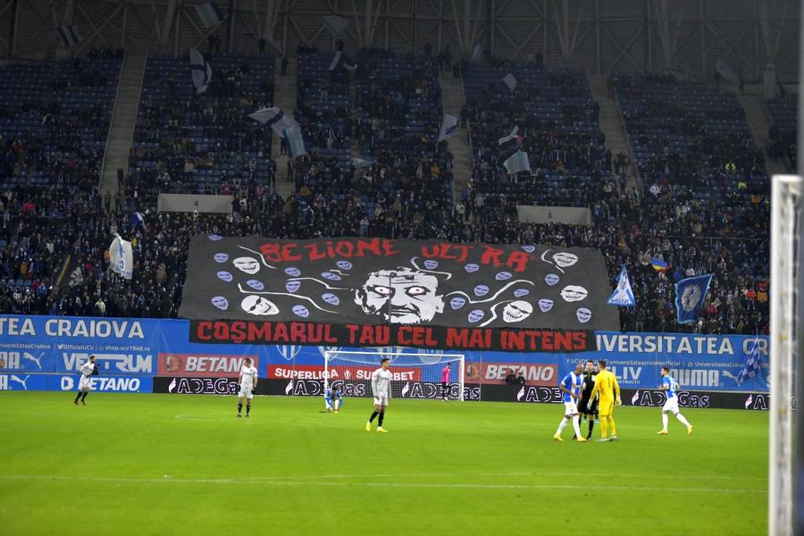 Imagine cu galeria Craiovei varianta Mititelu de la derby-ul cu rivala din oraș. Se vede clar din uriașul banner care este ținta manifestărilor ultrașilor olteni Despre suporteri. E dragoste sau e șantaj?