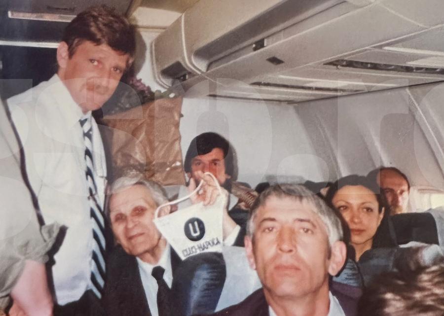 Sorin Bagiu alături de Seniorul Corneliu Coposu (cu fanionul), un mare fan al Universității Cluj, într-o deplasare cu avionul. Sursa: arhiva personală Interviu spectaculos cu fostul președinte al lui „U” Cluj: „Dacă luăm titlul, fac baie cu șampanie în Someș!” + Cum a salvat clubul de la dezastru: „L-am vândut pe două tone de material plastic”