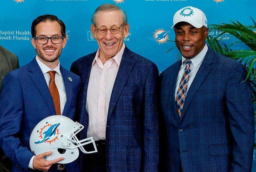 Antrenor principal al Dolphins, Mike McDaniel, alături de proprietarul Dolphins, Stephen Ross (centru) și de managerul general al echipei, Chris Grier, Foto: Imago Images Proprietarul unei echipe din NFL a fost amendat cu 1,5 milioane de dolari pentru că a încercat să-l transfere abuziv pe legendarul Tom Brady