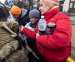 Locuitorii se înghesuie pentru a primi mâncare și alte articole oferite de membrii armatei ucrainene în Irpin, Ucraina