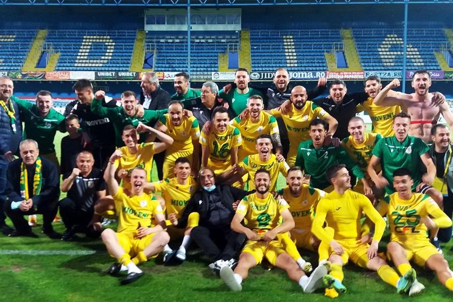 Ion Georgescu, în stânga jos, cu fularul la gât, la promovarea în Liga 1 a celor de la CS Mioveni, în iunie 2021 Omul care a susținut echipa în Superligă, prins în flagrant când restituia 10.000 de euro dintr-o mită » DNA l-a arestat preventiv pentru 30 de zile