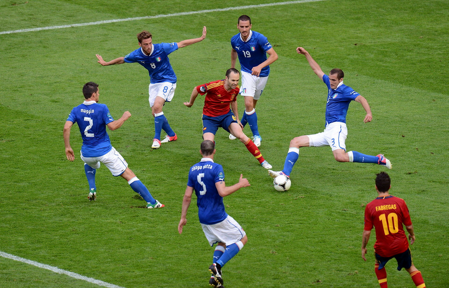 Andres Iniesta, între apărătorii Italiei - EURO 2012 Gloria Buzău profită de două gafe în defensivă și se impune la Sibiu » Lupta pentru salvarea de la retrogradare se complică și mai mult