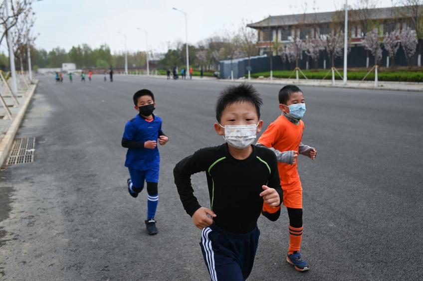 Copiii chinezi aleargă cu măști de protecție FOTO: Guliver/GettyImages