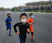 Copiii chinezi aleargă cu măști de protecție FOTO: Guliver/GettyImages