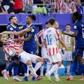 Michael Olise (cu coadă) și paraguayanul Matias Galarza (în cădere) au fost în „război” pe toată durata partidei Franța Paraguay (1-0) / Foto: Imago
