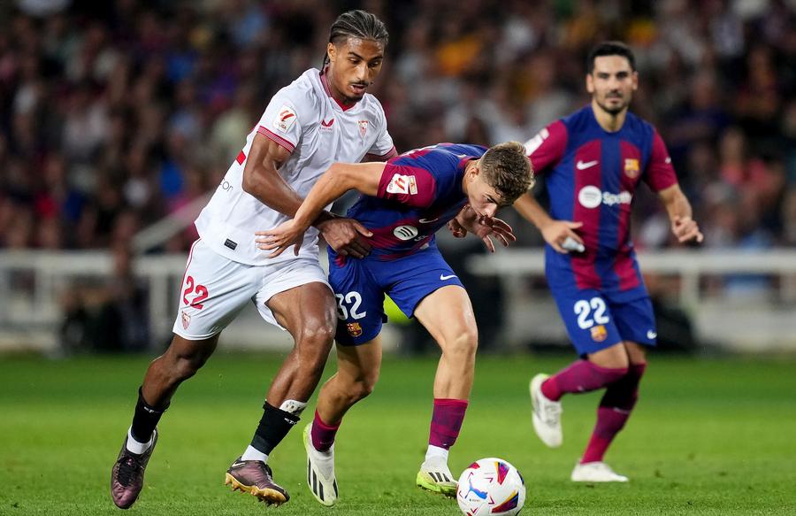 Loic Bade (stânga), surprins în timpul meciului Sevillei cu Barcelona Foto: Guliver/GettyImages Concurent din Spania pentru Radu Drăgușin la Tottenham » De ce Genoa cere mai mulți bani + Reacția lui Napoli