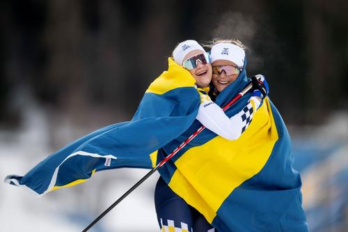 Frida Karlsson (dreapta) o îmbrățișează pe compatrioata Ebba Anderson după proba de 10+10km la JO Milano-Cortina Foto: Imago Images