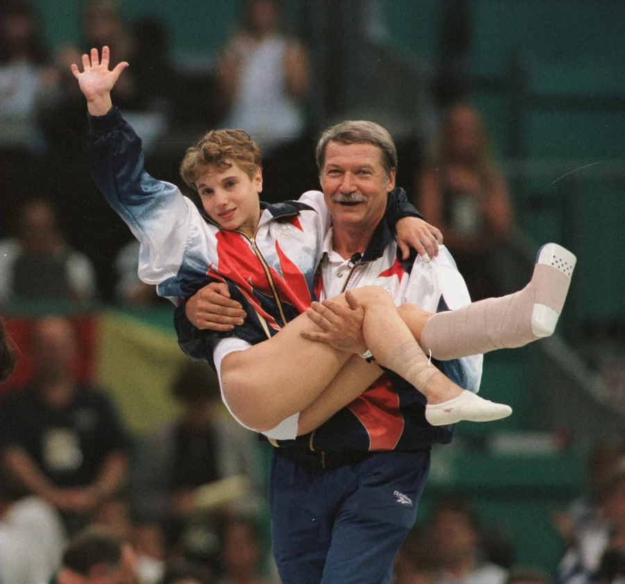 Imaginea de un milion de dolari, cu Bela Karoly purtând-o spre podium pe Kerri Strug la JO Atlanta 1996 10 episoade cu Bela Karolyi, antrenorul Nadiei Comăneci, care a decedat noaptea trecută: de la bătăile crunte aplicate sportivelor până la „clientul” Securității lui Ceaușescu