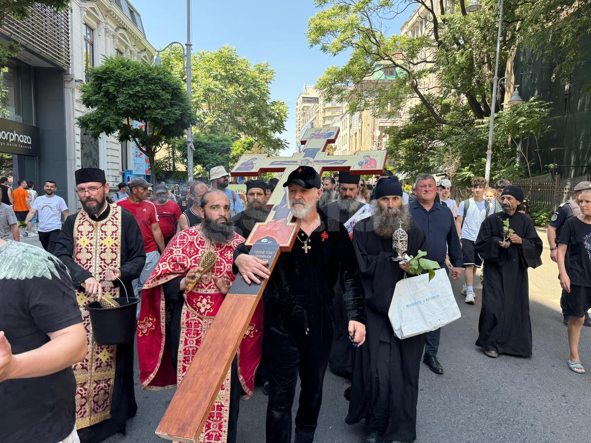 Gigi Becali a ieșit pe Calea Victoriei să „curețe” cu agheasmă după marșul LGBT: a purtat o cruce uriașă, apoi s-a oprit și a cântat