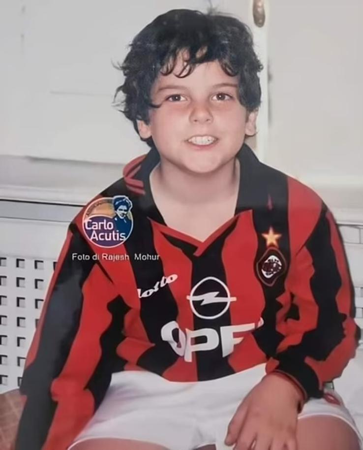 Carlo Acutis, surprins zâmbind către cameră, purtând echipamentul de acasă al echipei AC Milan din anii 1990.