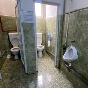 Două grupuri sanitare, instalații improvizate, un pișoar defect și instrucțiuni de folosire lipite pe pereți