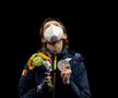 Cu medalia de argint în mână, Ana Maria Popescu privește zâmbind în sus, acolo unde sunt îngerii