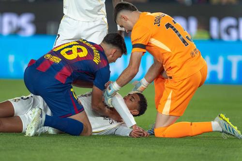 Jude Bellingham primește ajutor din partea jucătorilor Barcelonei după cotul lui Eric Garcia / Foto: Imago