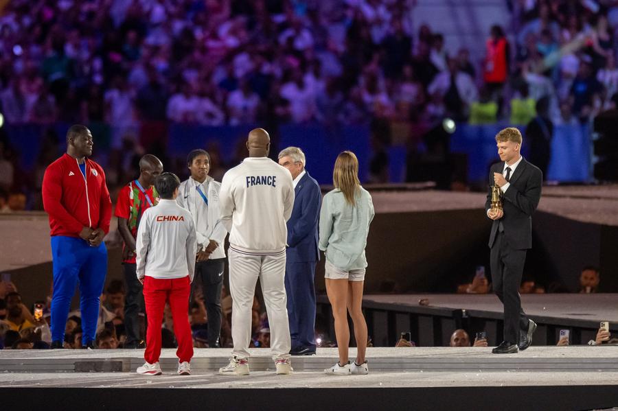 Leon Marchand aducând flacăra olimpică Jocurile Olimpice de la Paris au fost declarate închise! Reporterii GSP au asistat la un eveniment unic: Tom Cruise a coborât de pe Stade de France și a preluat ștafeta pentru următoarea ediție