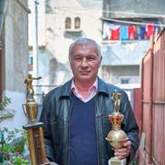Ilie Dragomir pozând în curtea din Ferentari cu două dintre cele mai dragi cupe ale sale