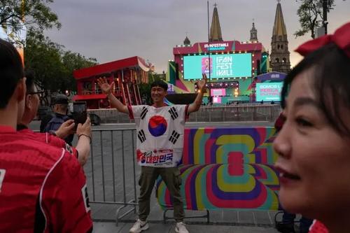 Un fan sud-coreean pozează în fața unei scene instalată la un festival al fanilor din Guadalajara, pe 10 iunie