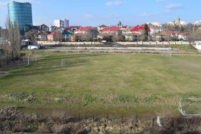 Fostul stadion arată jalnic, pe fundal se zărește noua arenă, cunoscută ca OZN-ul din Bănie