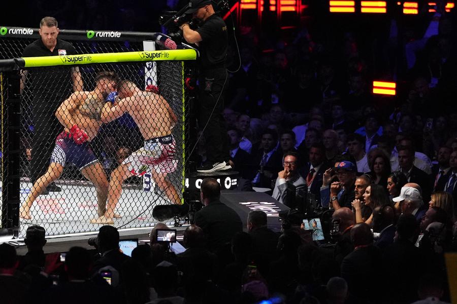 Luptători MMA, în cușca din fața Casei Albe, urmăriți de președintele Donald Trump, cu o șapcă albă, în dreapta imaginii, foto: Imago Donald Trump în cușcă, Nero la Colosseum