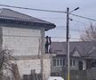 Oamenii urmăresc partida de pe o casă în construcție din apropierea terenului FOTO: Cătălin Stroia