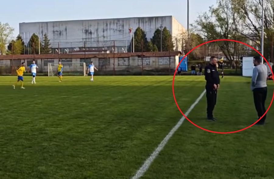Un jandarm îl ia la întrebări pe bărbatul care oferea indicații de pe banca Științei Delești / Sursă foto: Facebook@ Religia Sportului Scene neverosimile la un meci din România » Jandarmul a venit pe teren și a legitimat un jucător în timpul meciului! Explicații oficiale: „A avut o atitudine proactivă”