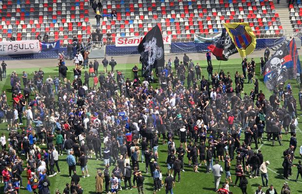 „Pentru noi ați promovat!” » Imagini incredibile în Ghencea: mii de suporteri au dat năvală pe teren, imediat după o bătaie între oficialii Stelei și ai Reșiței