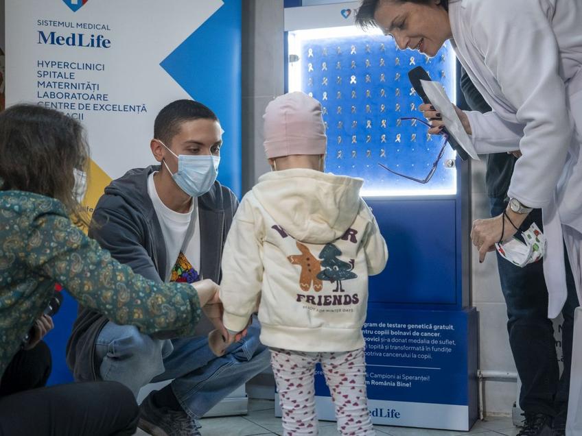 David Popovici oferind una dintre fundițele confecționate din medalia sa de aur FOTO Raed Krishan