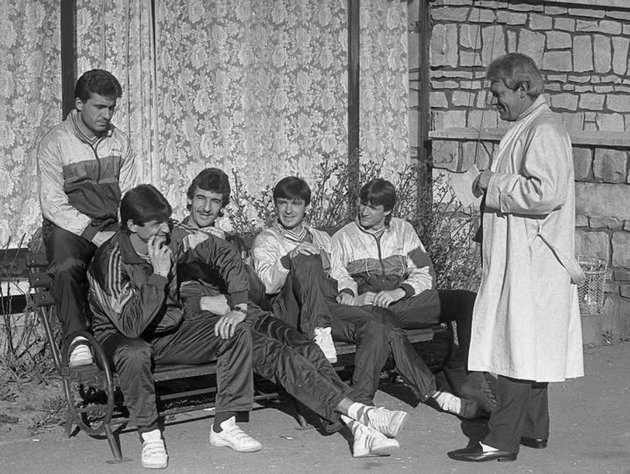 Emil Săndoi (primul din dreapta pe canapea) alături de Hagi, Iovan, Lung, Mateuț și selecționerul Emeric Ienei la Mondialul italian din 1990 Emil Săndoi, „Eugen” de la Securitate: „Știe ce are de făcut la lot” + Ce a scris despre Gică Popescu „Petrescu” și conexiunile incredibile cu dosarul de agent al „Baciului”