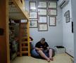Kyuta se joacă un joc în dormitorul său. Pe perete sunt medaliile și premiile sale. // Foto: Reuters
