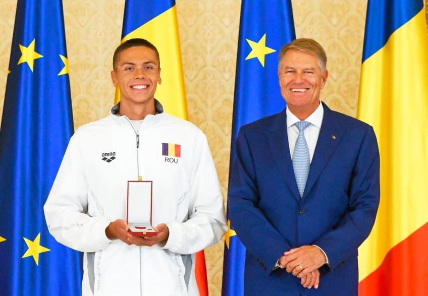 David Popovici (17 ani) și antrenorul Adrian Rădulescu (32 de ani) au fost decorați astăzi de președintele Klaus Iohannis (63 de ani).