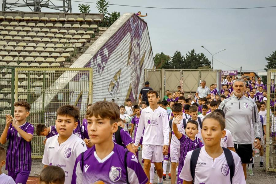Coordonatorul academiei, Bogdan Vișan, în mijlocul tinerilor viitori fotbaliști / Sursă foto: Facebook@ FC Argeș Una dintre școlile legendare de fotbal ale României promite să „producă” din nou: „A venit momentul ca echipele din țară să se teamă de noi!”. Dar părinții acuză selecții făcute pe pile!