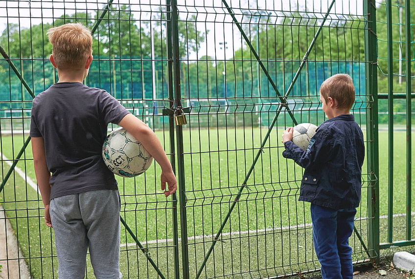Imagine realizată ieri, de fotoreporterul GSP Raed Krishan, cu 2 copii privind prin gard la terenurile de sport zăvorâte dintr-un parc bucureștean