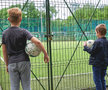 Imagine realizată ieri, de fotoreporterul GSP Raed Krishan, cu 2 copii privind prin gard la terenurile de sport zăvorâte dintr-un parc bucureștean