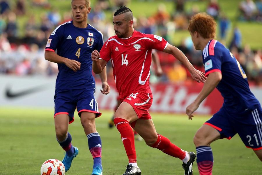 Abdallah Jaber, în roșu, într-un duel cu Japonia // Foto: Getty Images Povestea fraților crescuți în aceeași casă, dar care reprezintă naționale diferite, aflate în conflict