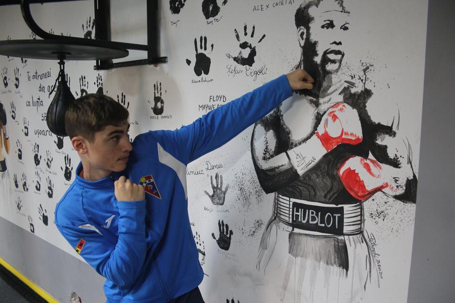 Ipostază cu Șerban Stoica în sala de box din Suceava: o directă simbolică în falca idolului Floyd Mayweather. Foto: Justin Gafiuc (GSP) Puștiul cu pumni de aur din boxul românesc: „N-am zis niciodată «Nu mai pot» sau «Nu mai vreau». Când intru în ring, sunt în transă”