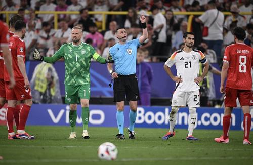 Arbitrul Michael Oliver le arată jucătorilor că pe copertina stadionului se află un individ și le spune că va urma o intervenție a forțelor speeciale SEK / Foto: Imago