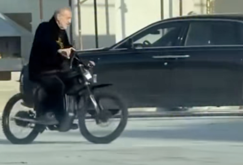 Gigi Becali, pe bicicletă electrică în curtea bisericii