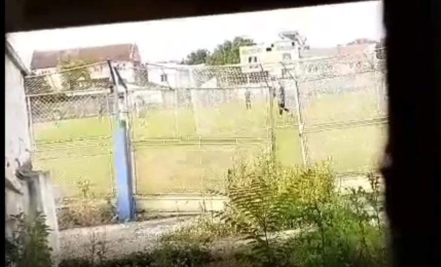 Imagine surprinsă printr-o spărtură în gard, la peluza stadionului Olimpia din Satu Mare. Pe teren se joacă CSM - Recolta 5-1 VIDEO EXCLUSIV Satu Mare, tupeu și mai mare: play-off ilegal, la negru, jucat sub ochii primarului fără mască și ai AFJ: ”Dacă vine DSP-ul, spuneți că jucați un amical”