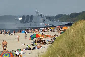 Десантен кораб "изплува" на претъпкан плаж (видео)