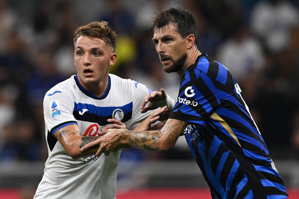 Mateo Retegui, avançado da Atalanta, e Francesco Acerbi, defesa do Inter, agarram-se mutuamente durante jogo entre as duas equipas que nesta noite de quinta-feira decidem o primeiro finalista da Supertaça italiana