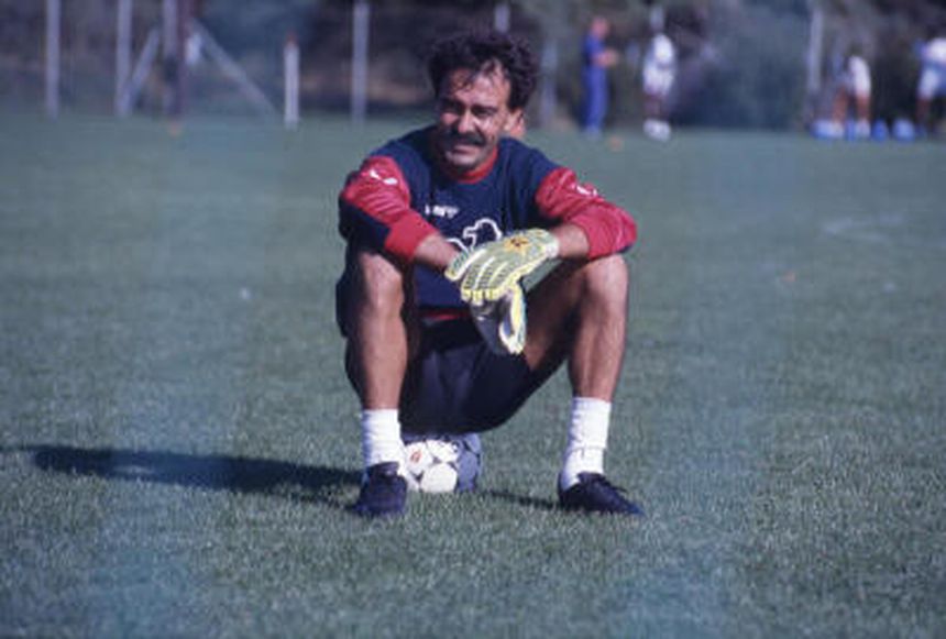 Manuel Bento sentado no relvado do antigo Estádio da Luz, com a camisola do Benfica