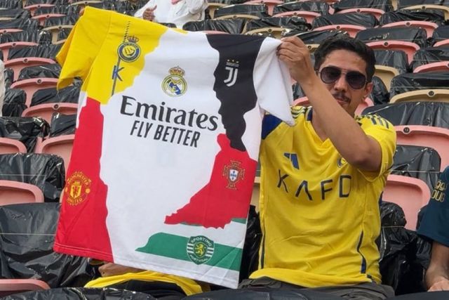 Adepto ergue orgulhosamente camisola alusiva aos clubes que Cristiano Ronaldo já representou