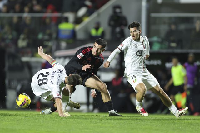 Rúben Lima, no chão, em ação acrobática, a tentar desarmar Amdouni, com Paulo Moreira atento ao lance (António Cotrim/LUSA)