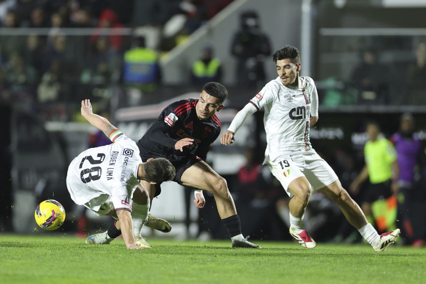 Rúben Lima, no chão, em ação acrobática, a tentar desarmar Amdouni, com Paulo Moreira atento ao lance (António Cotrim/LUSA)
