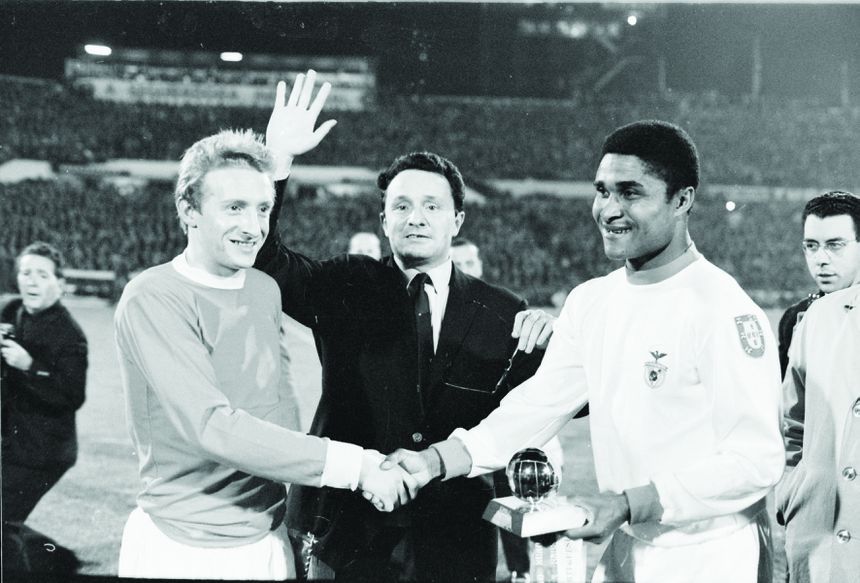 Sob o olhar de Denis Law, Eusébio recebe no Estádio da Luz, antes do Benfica-Manchester United, a Bola de Ouro da 'France Football', atribuída ao melhor jogador da Europa