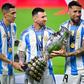 Di María, Messi e Otamendi com o troféu de campeão do mundo