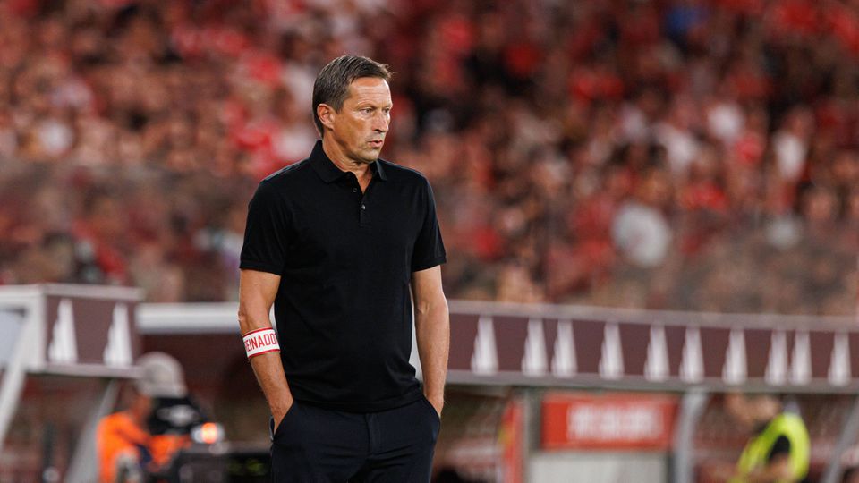 Roger Schmidt com as mãos nos bolsos das calças durante um jogo do Benfica