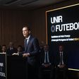 Imagem de Pedro Proença a dicursar na manhã de segunda-feira, 3 de fevereiro, durante a apresentação da sua candidatura à presidência da Federação Portuguesa de Futebol. «Unir a comunidade do futebol» é o que se lê em pano de fundo