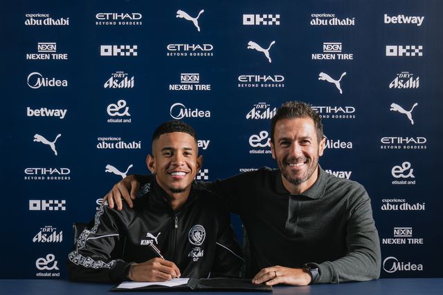 Savinho a assinar contrato ao lado de Hugo Viana, diretor desportivo do Man. City