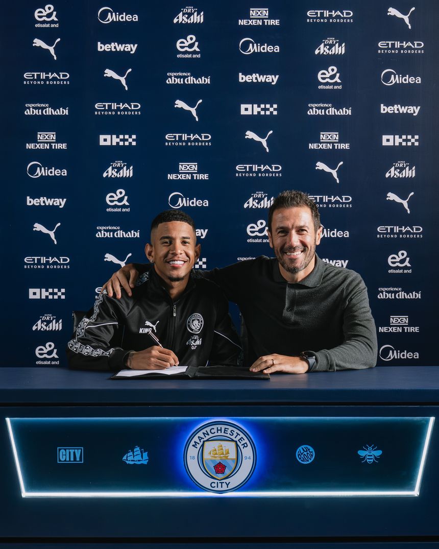 Savinho a assinar contrato ao lado de Hugo Viana, diretor desportivo do Man. City
