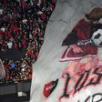 Bandeira dos adeptos do Newells Old Boys com desenho de Messi a dar toques em criança